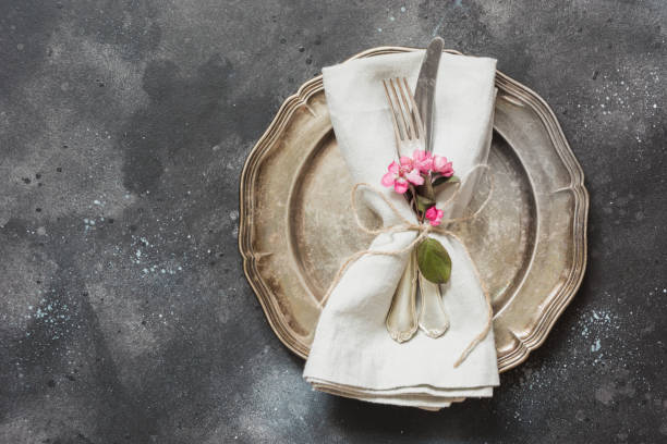 istock Table place setting with pink flowers, silverware on vintage background. View from above. 959986914