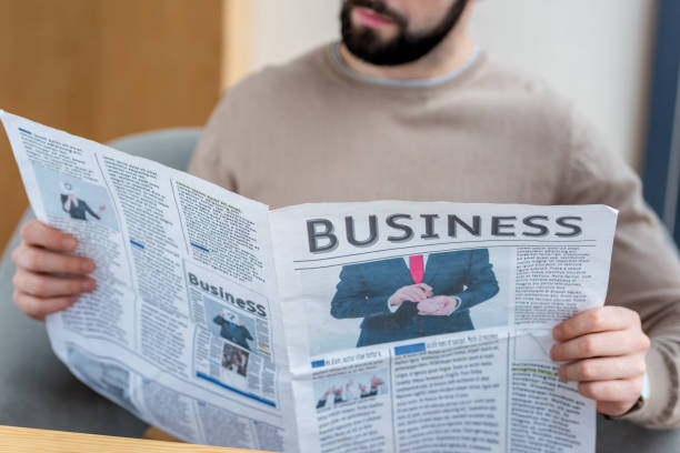 istock Cropped image of man reading business newspaper 959987348