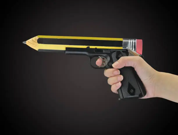 Hand holding gun with pencil point isolated on black
