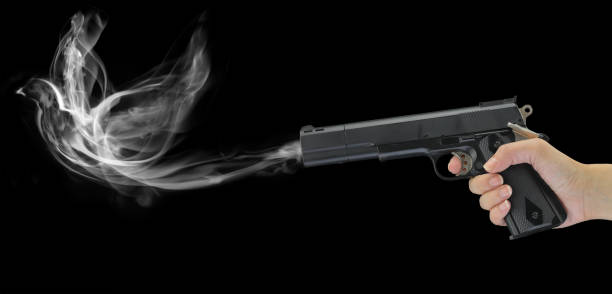 istock Hand holding a smoking gun isolated on black 960005370