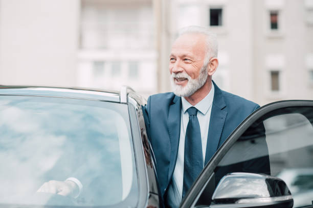istock Senior white collar worker entering business car 960016864