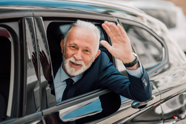 istock Senior businessman waving hand from car window 960017004