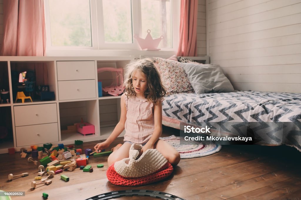 child girl cleaning her messy room and put toys in basket Child Stock Photo