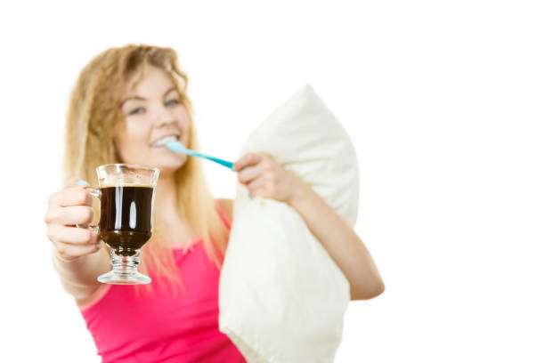 Happy woman holding toothbrush and coffee going to brush her teeth after hot drink.