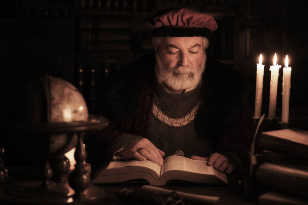 istock Senior scholar of the past reading book in old library 960021140