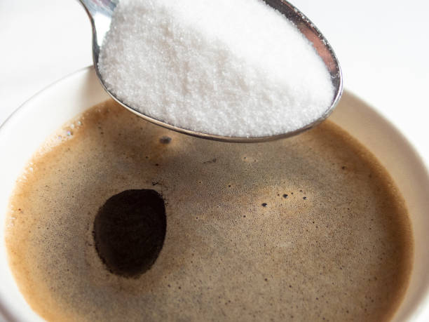 istock Coffee in Cup with Sugar in Spoon above it Close-up 960021328