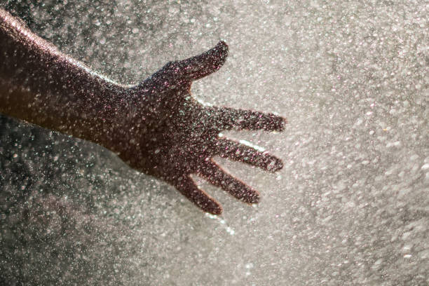 istock Water drops and hand - holding hand in water splash - 960021424