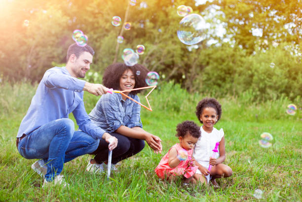 istock Happy family playing soap bubbles in park. 960024658