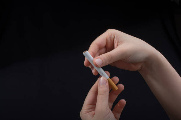 istock Hand is holding a cigarette on black background 960028412