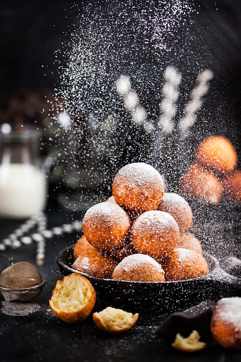 Fresh delicious homemade cottage cheese ball donuts with powdered sugar on dark background