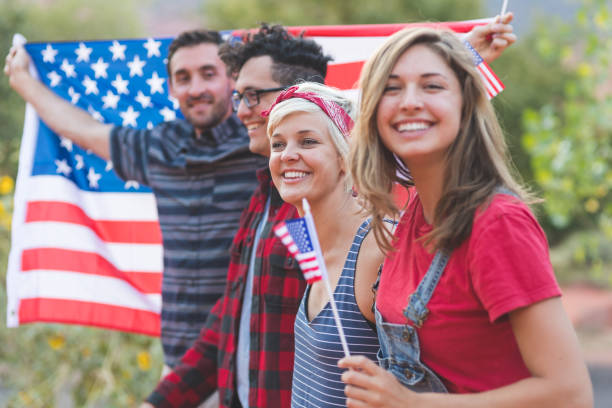 group of millennial friends hold a large american flag - parade rest imagens e fotografias de stock