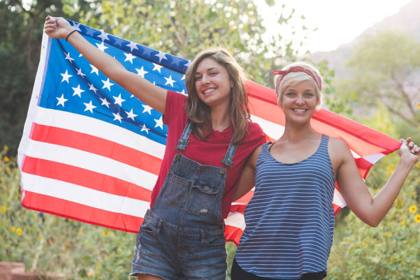 istock Two friends drape themselves in an American flag outside 960035246