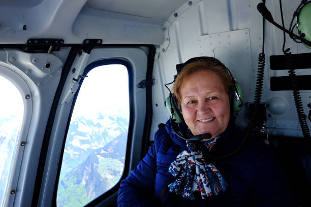 senior woman in helicopter flight - eiger mountain swiss culture photography imagens e fotografias de stock