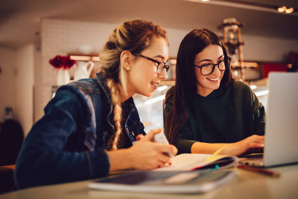 istock Female university students with laptop studying together at coffee shop 960039180