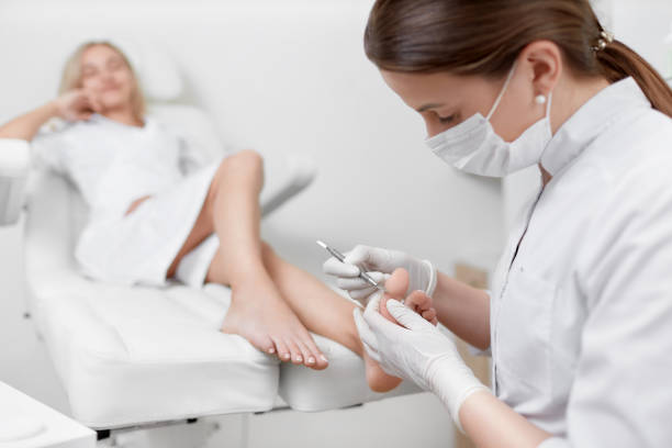 istock Podiatrist doctor caring about client foot with special iron tool 960054310