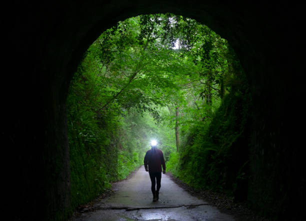 istock Hiker illuminating the path when entering a tunnel. 960054684