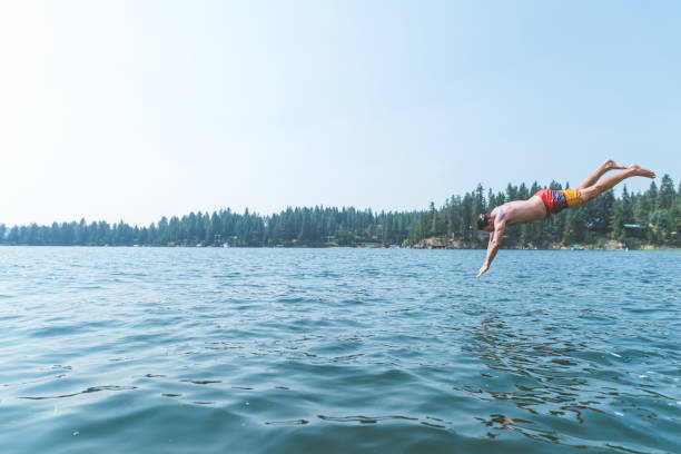 istock Young man dives into a pristine lake 960059378