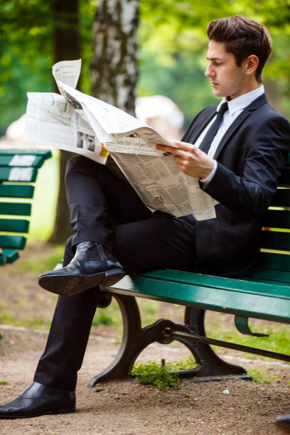 Paris, France - July 15, 2008: Man relaxing and reading the newspaper in the Luxembourg Gardens. Copy space available at the right of the frame.