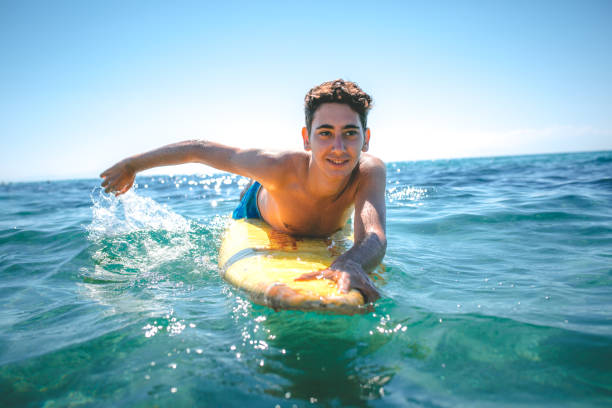 Young men surfing in ocean
