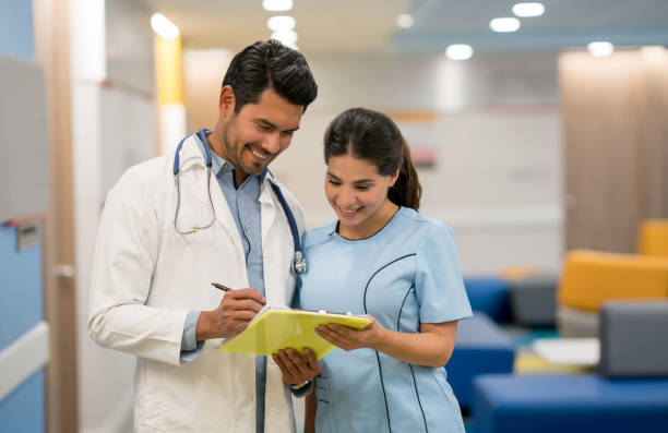 istock Young nurse looking at something the doctor is pointing on a clipboard both looking very happy 960073300