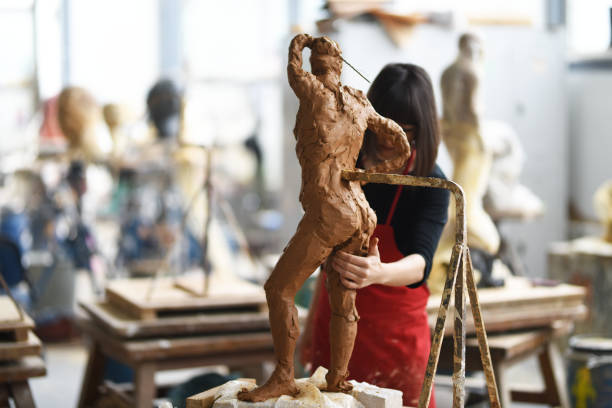istock Young Female Sculptor is working in her studio 960073486