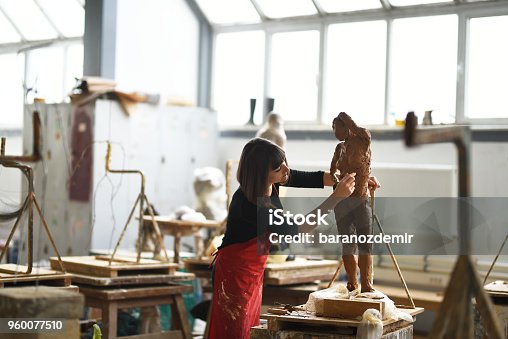 istock Young Female Sculptor is working in her studio 960077510