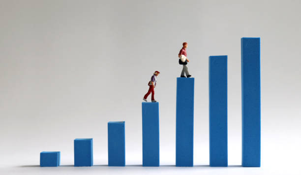 istock Two miniature people walking on a blue bar graph. Economic income gap concept. 960078302