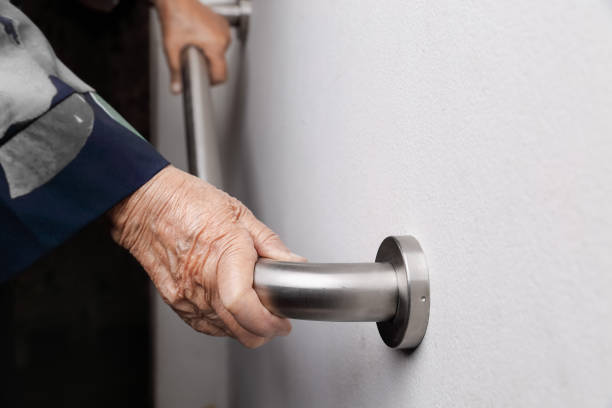 istock Elderly woman holding on handrail for safety walk steps 960093598