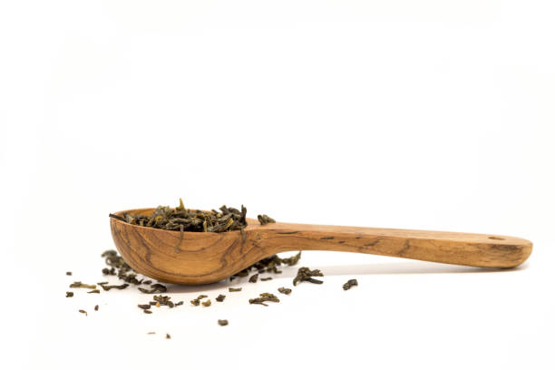 Tea leaves on wooden spoon. stock photo