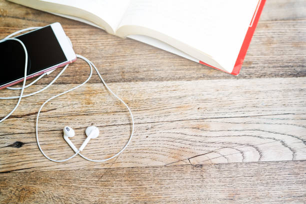 istock white heart shape earphone with smartphone and open book on working table top view with copy space 960103782