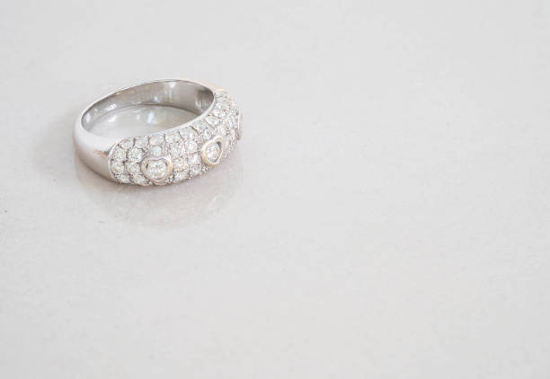 istock Closeup old diamond ring on blurred marble stone floor background 960112012