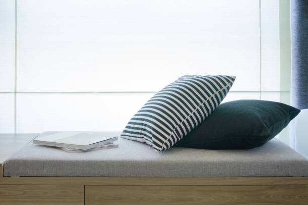 istock Comfortable seat next to window with pillows and books 960114846