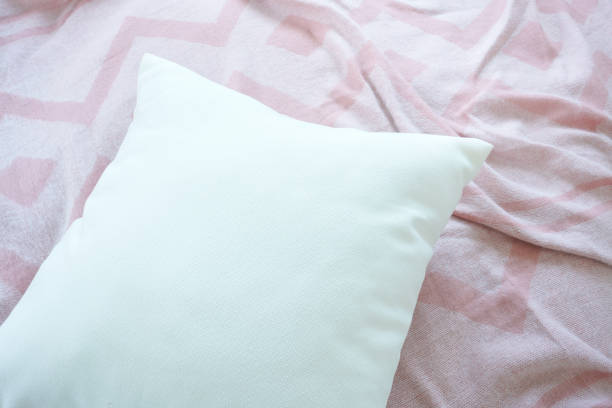 istock Close up white pillow on messy pink fabric background 960115216