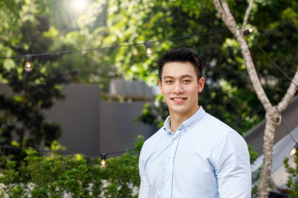 Portrait Of Young Asian Man Portrait Of Young Asian Man In Outdoor Setting male chinese student stock pictures, royalty-free photos & images