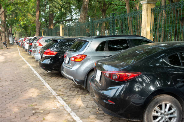 istock Parallel cars parking on street with green trees 960121968
