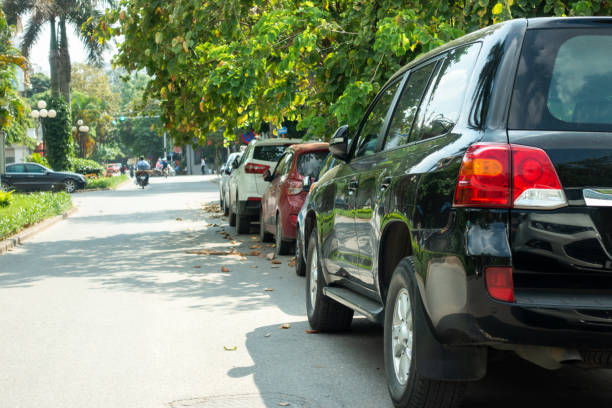 istock Parallel cars parking on street with green trees 960122234