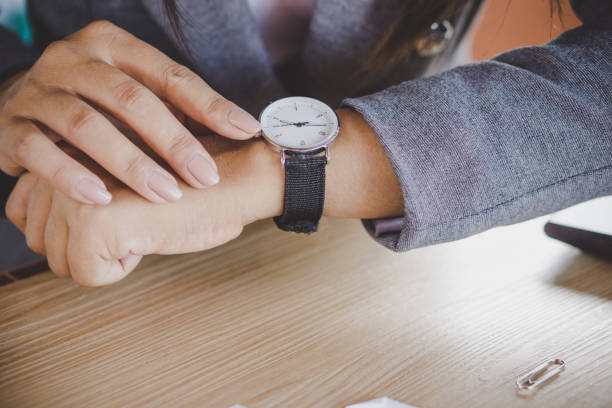 femme d’affaires, regarder l’heure sur la montre - checking the time watch women looking photos et images de collection