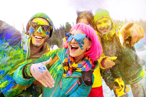 Group of happy friends in colorful clothes is having fun at holi color festival