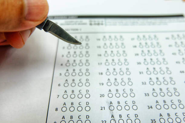 istock The left hand holds the pen knife to selected choice on answer sheets 960140238