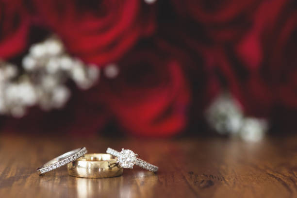 Gold wedding rings with red roses stock photo