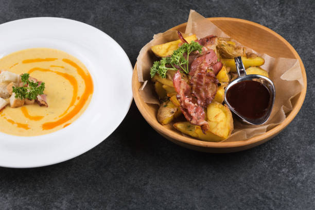 istock Complex dinner. Fried potatoes with appetizing bacon and sauce are in a wooden plate 960144474