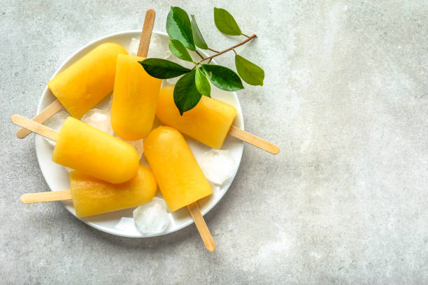istock Natural juicy orange popsicles. Refreshing ice pops, overhead, flat lay 960145774