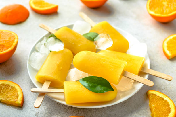 istock Fruit popsicles with orange frozen juice, refreshing summer ice cream on stick 960146110