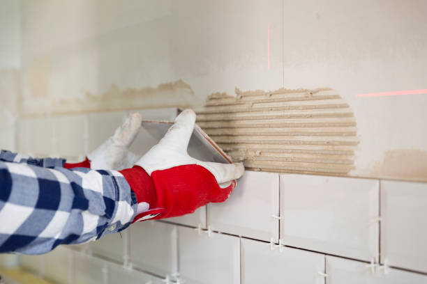 Process of tiling the tiles in the kitchen with necessary tiling tools. Home improvement, renovation concept stock photo