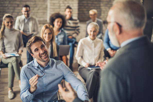 istock Happy entrepreneurs talking to public speaker on a seminar in a board room. 960151200