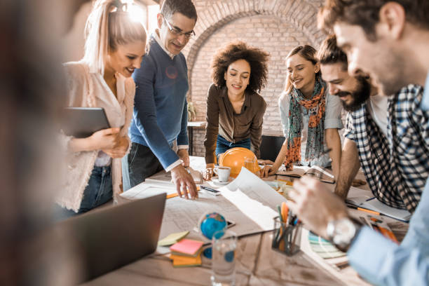 istock Team of happy architects analyzing blueprints on a meeting in the office. 960151772