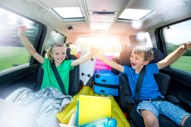 子供たちは長い車の旅行の間に車の中でリラックスします。 - キャンプ　準備 ストックフォトと画像