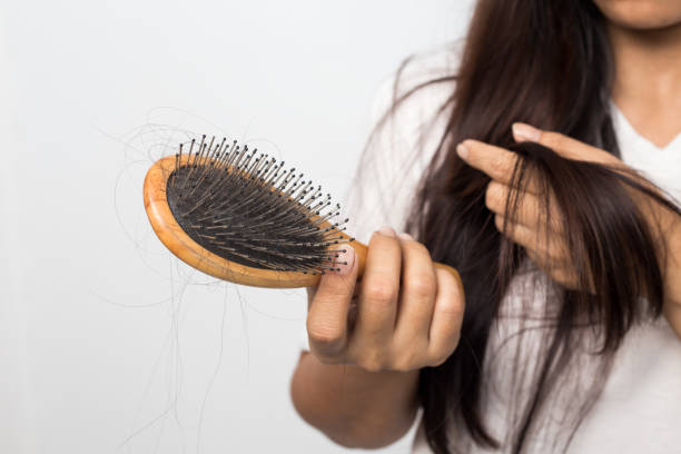young woman worried about hair loss on a white stock photo