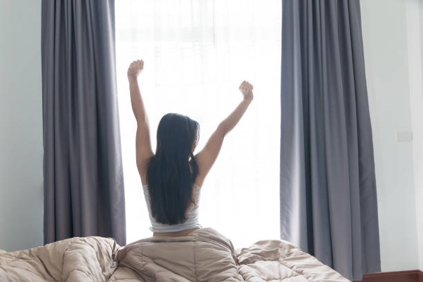 istock asian young woman stretching on bed after waking up 960156654
