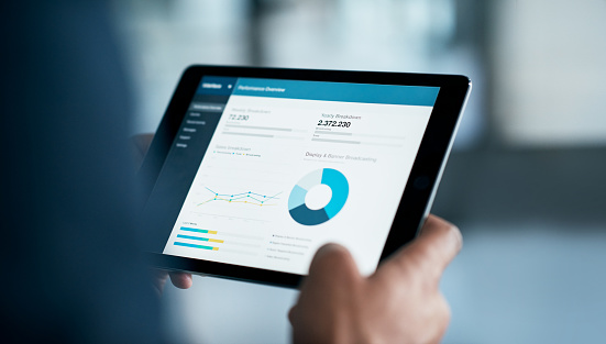 Closeup shot of a businessman analyzing statistics on a digital tablet in an office